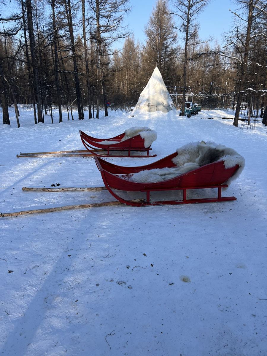 Red reindeer sleds lined up in the snow at Aoluguya