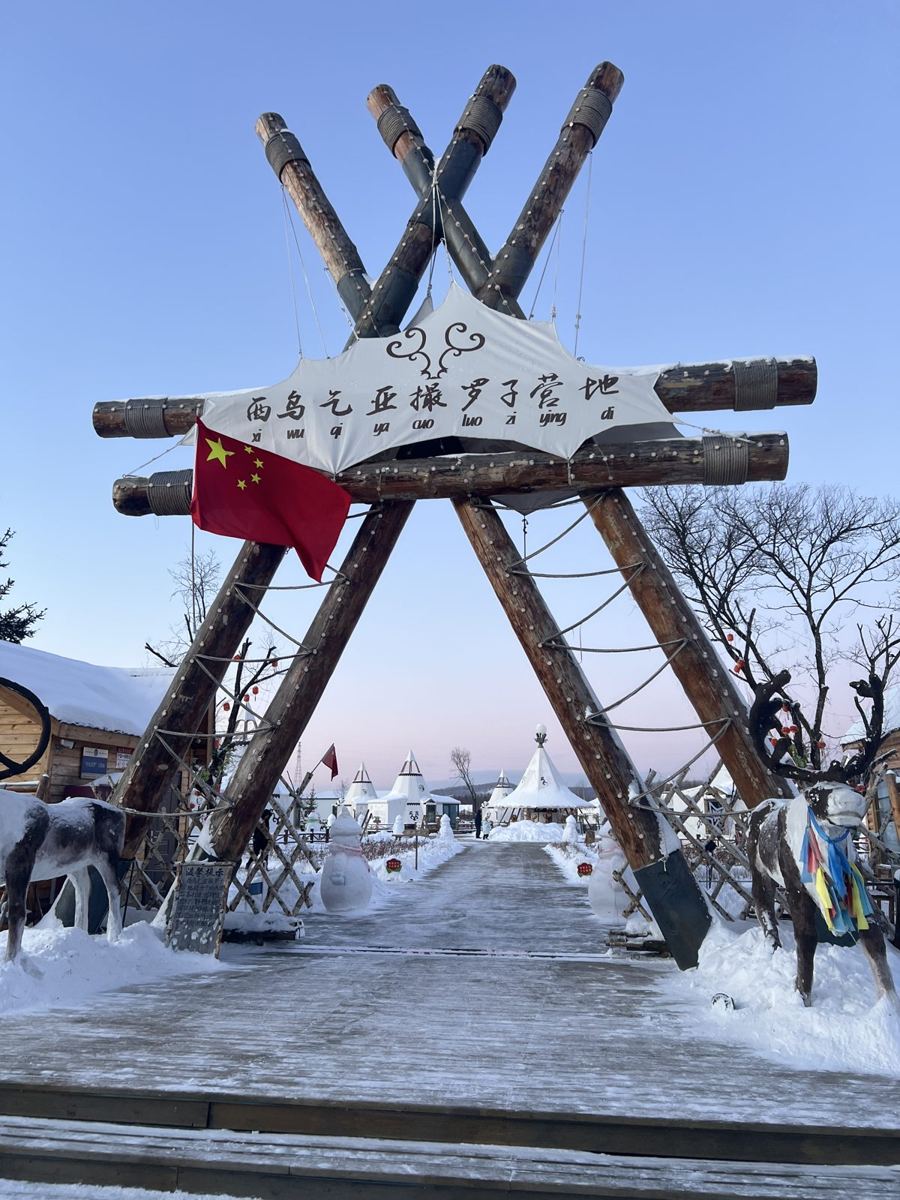 The wooden entrance gate to Aoluguya reindeer village in the snow