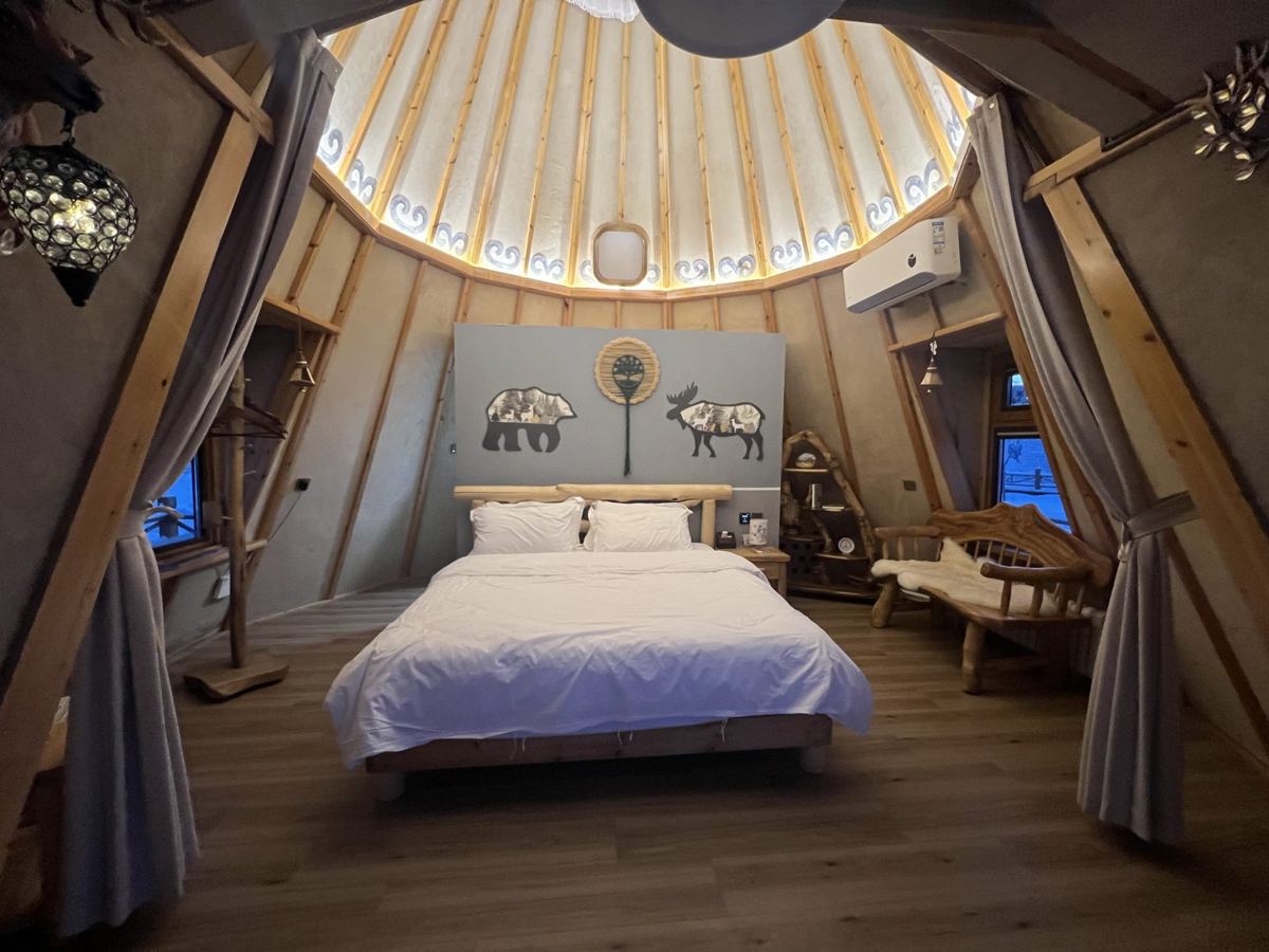 Inside a heated yurt at Aoluguya with a bed and wooden floors