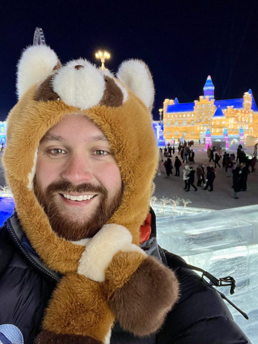 John in a fuzzy animal hat at Harbin Ice and Snow World at night